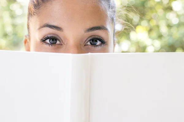 Closeup portrait of woman with white book looking at camera. — Stock Photo, Image