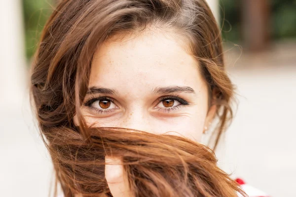 Gros plan portrait de heureuse jeune femme couvre son visage de cheveux . — Photo