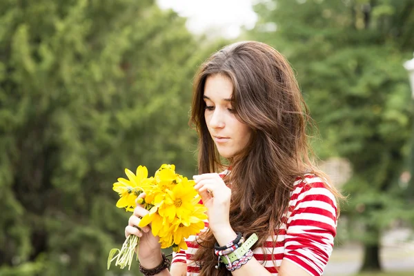 Belle femme romantique avec bouquet de fleurs dans le parc . — Photo