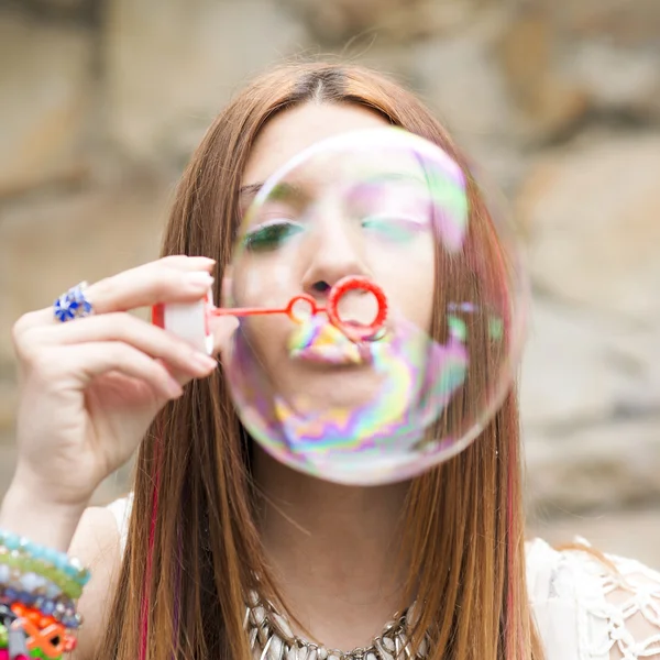 Retrato de close-up de mulher bonita inflando bolhas de sabão coloridas . — Fotografia de Stock