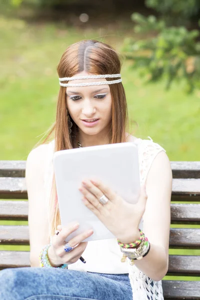 Mujer hermosa joven buscando mensaje en la computadora de la tableta, outdoo — Foto de Stock