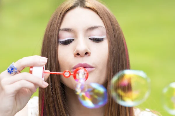 Gros portrait de belle femme gonflant des bulles de savon colorées . — Photo