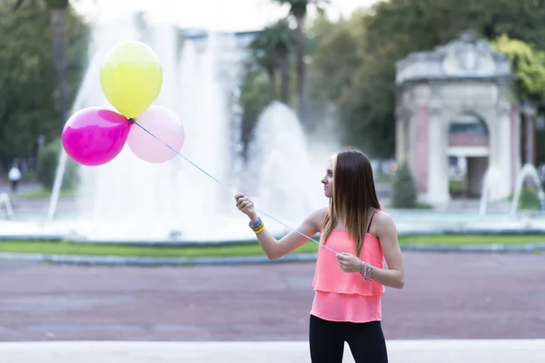 Glückliche Frau spielt Luftballons im Park. — Stockfoto