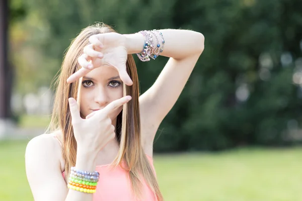 Portrait of beautiful young woman making frame with her hands. — Stock Photo, Image