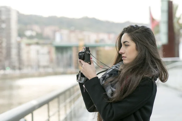 Mulher bonita fechando com câmera retro na rua . — Fotografia de Stock