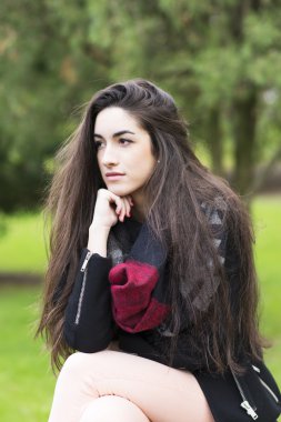 Parkta güzel zarif bir genç kadın portresi.