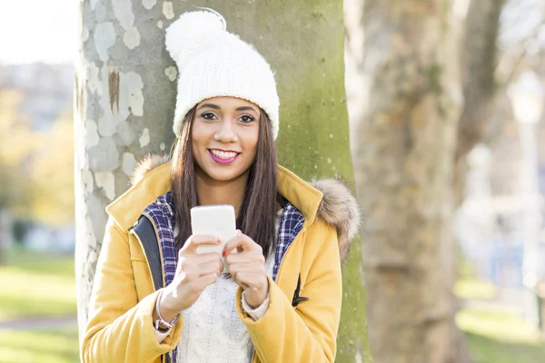 Retrato de la mujer de la felicidad con sombrero sosteniendo el teléfono, al aire libre . —  Fotos de Stock