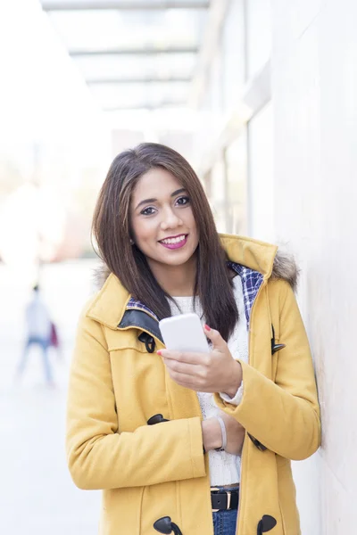 Красивая счастливая женщина держит смартфон на улице . — стоковое фото