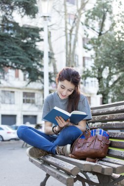 Tezgah ve kitap okumak, açık üzerinde oturan mutluluk kadın.
