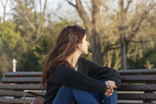 Mujer hermosa pensativa en el parque mirando hacia otro lado . —  Fotos de Stock