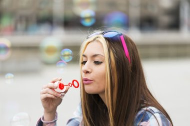 Kentsel boobbles ile oynarken güzel genç kız portresi.