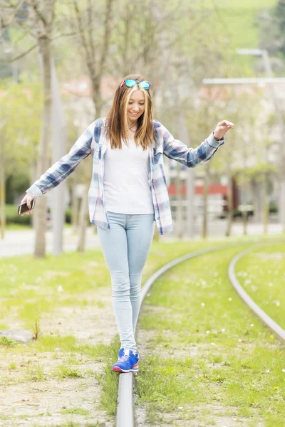 Felicidade menina bonita caminha no velho trilho na rua . — Fotografia de Stock