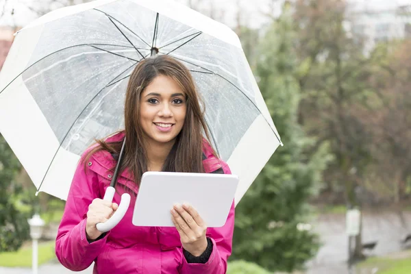 Mujer de la felicidad con paraguas y tableta en el parque . — Foto de Stock