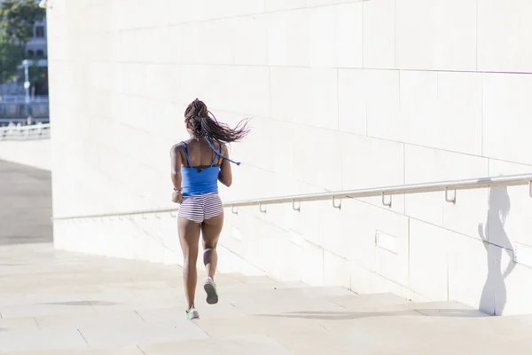 Спортивная африканская женщина, бегущая по улице, концепция здорового образа жизни . — стоковое фото
