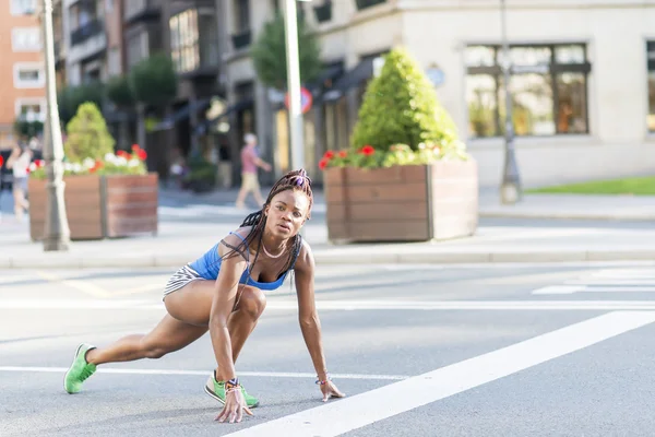 Schöne afrikanische Sportlerin bereit, auf der Straße auf der Straße zu laufen. — Stockfoto