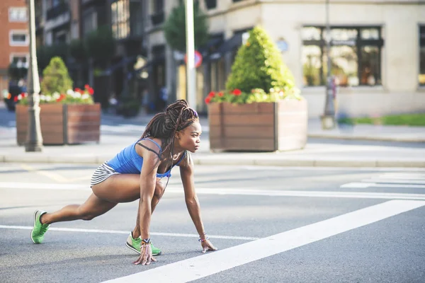 ผู้หญิงนักกีฬาแอฟริกันที่สวยงามพร้อมที่จะวิ่งบนถนนในถนน . — ภาพถ่ายสต็อก