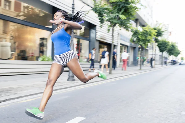 ぼかし効果を通り、動きで走っているスポーティなアフリカ女性. — ストック写真