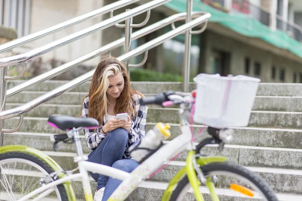 Bella ragazza urbana con bicicletta utilizzando il telefono, concetto di stile di vita adolescenziale . — Foto Stock