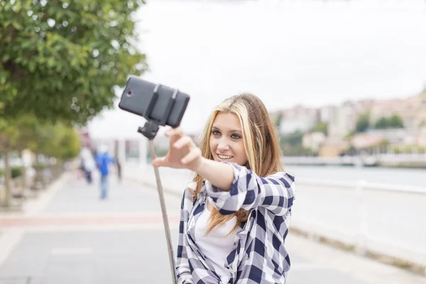 Jonge lachende vrouw is selfie in het concept van de straat en nieuwe technologieën. — Stockfoto