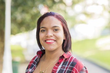 Gülümseyen genç latin kadın, açık portresi.