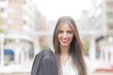 Gülümseyen iş kadını sokakta kamera bakıyor.