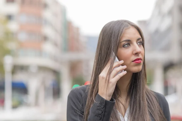 Nachdenkliche Geschäftsfrau telefoniert und schaut weg. — Stockfoto