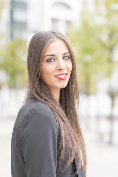 Femme d'affaires souriante regardant la caméra dans la rue . — Photo