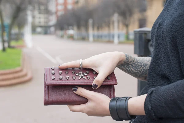 Händer med tatuering öppna plånbok på gatan. — Stockfoto
