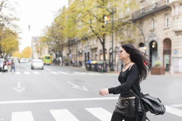 Hermosa mujer con gafas de sol estilo heavy metal caminando por la calle . —  Fotos de Stock