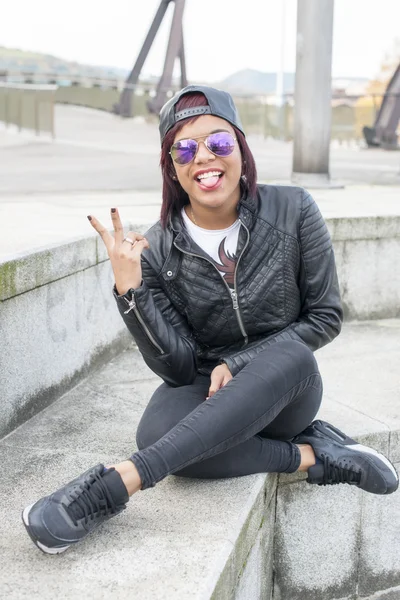 Hipster podekscytowany piękna kobieta z okulary pokazano jej język na ulicy. — Zdjęcie stockowe