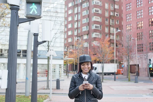 面带笑容的女人，在智能手机中的街道、 城市生活方式的概念上看消息. — 图库照片