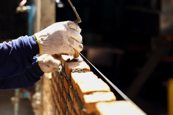 Trabalhadores alvenaria tijolo de argila à parede . — Fotografia de Stock