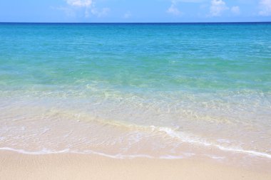 Deniz ve güneşli gökyüzü güzel kumlu plaj.