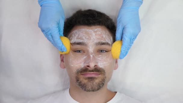 Kosmetikerin wäscht männliches Gesicht — Stockvideo