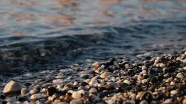 Küçük dalgalar kayaların üzerinde yuvarlanır
