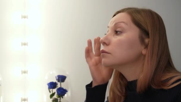 Mulher aplica creme de cuidados com a pele — Vídeo de Stock