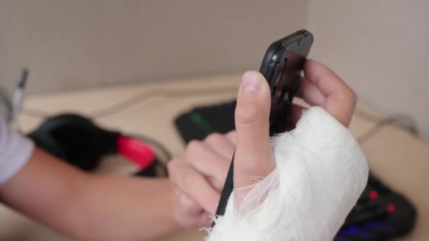 Рука в гипсе использует телефон — стоковое видео