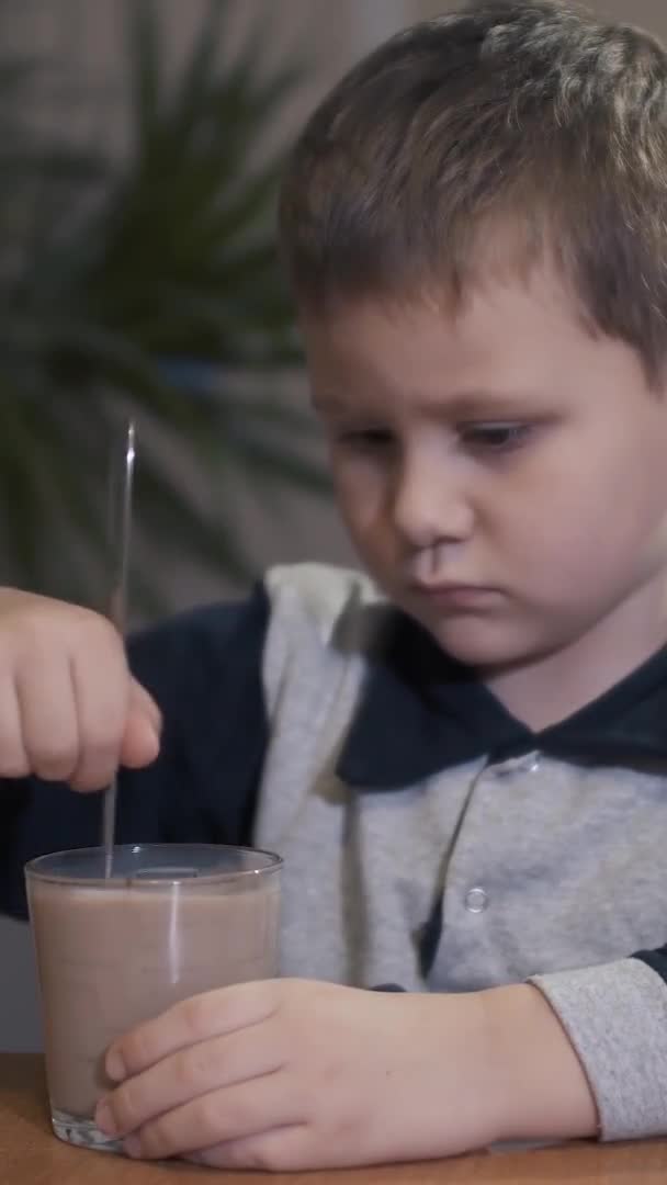 Vídeo vertical de menino mexe milkshake — Vídeo de Stock