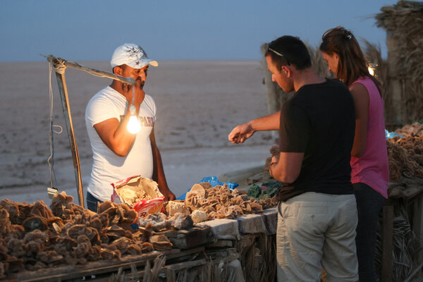 Tourists buying desert rose souvenir at Chott El Jerid