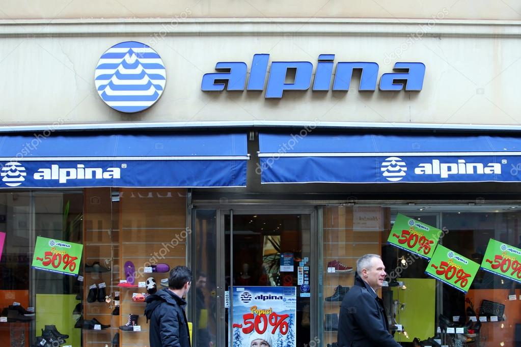 ZAGREB, CROATIA - FEBRUARY 24 : People in the street passing by the shopwindow of Alpina store with discount signs on February 24th, 2014 in Zagreb, Croatia. Alpina is a slovenian shoe manufacturing company.