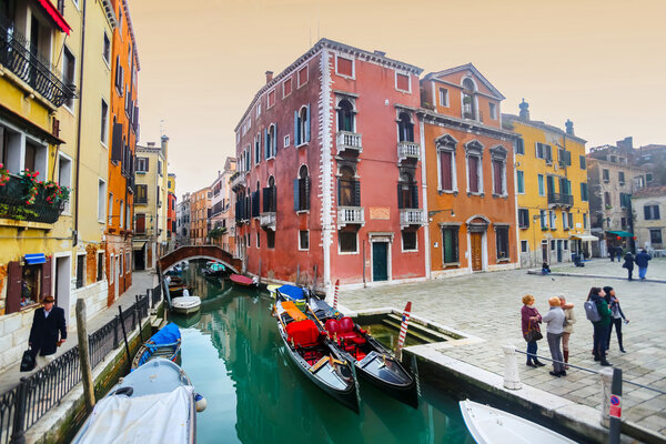 Gondolas moored along water canal in Venice