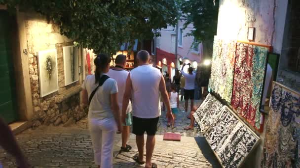 Toeristen lopen naast weergegeven souvenirs in Rovinj — Stockvideo