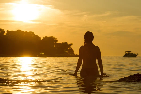 Žena, která stála v mělkých při západu slunce — Stock fotografie
