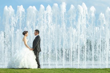 Gelin ve damat su çeşme önünde elele