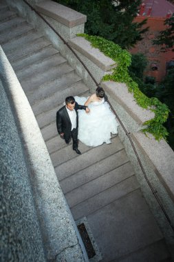 Yeni evliler taş basamaklardan iniyor