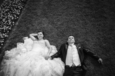 Gelin ve damat ile'nın bahçesinde el ele tutuşarak çiçekler bw