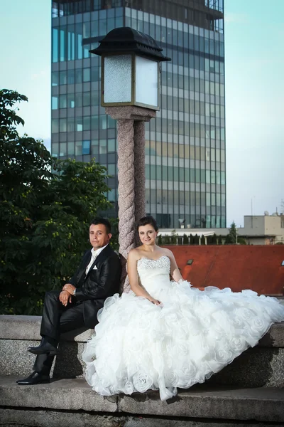 Recém-casados sentados ao lado da lâmpada de rua — Fotografia de Stock