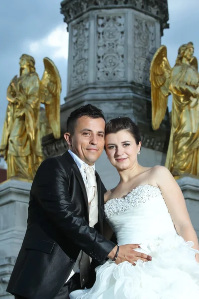 Bride and groom in front of fountain — Stock Photo, Image