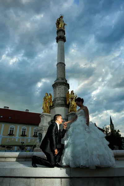 新娘和新郎摆在城市喷泉前 — 图库照片