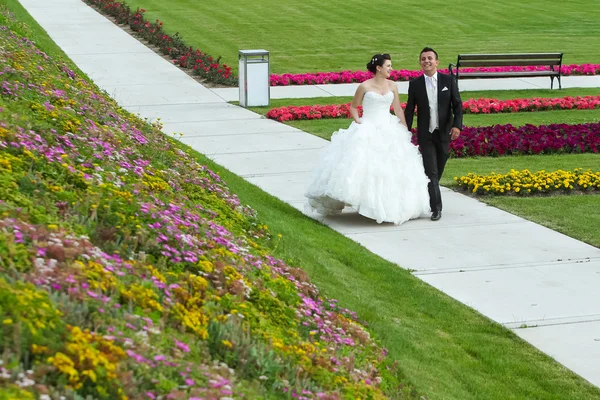 Bruid en bruidegom lopen op traject — Stockfoto